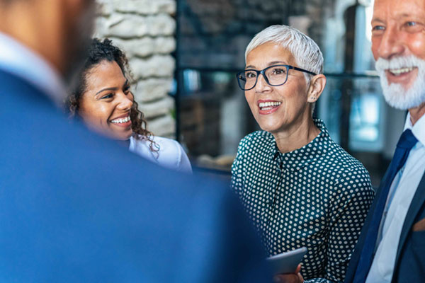 Senior executive woman smiling at her colleagues